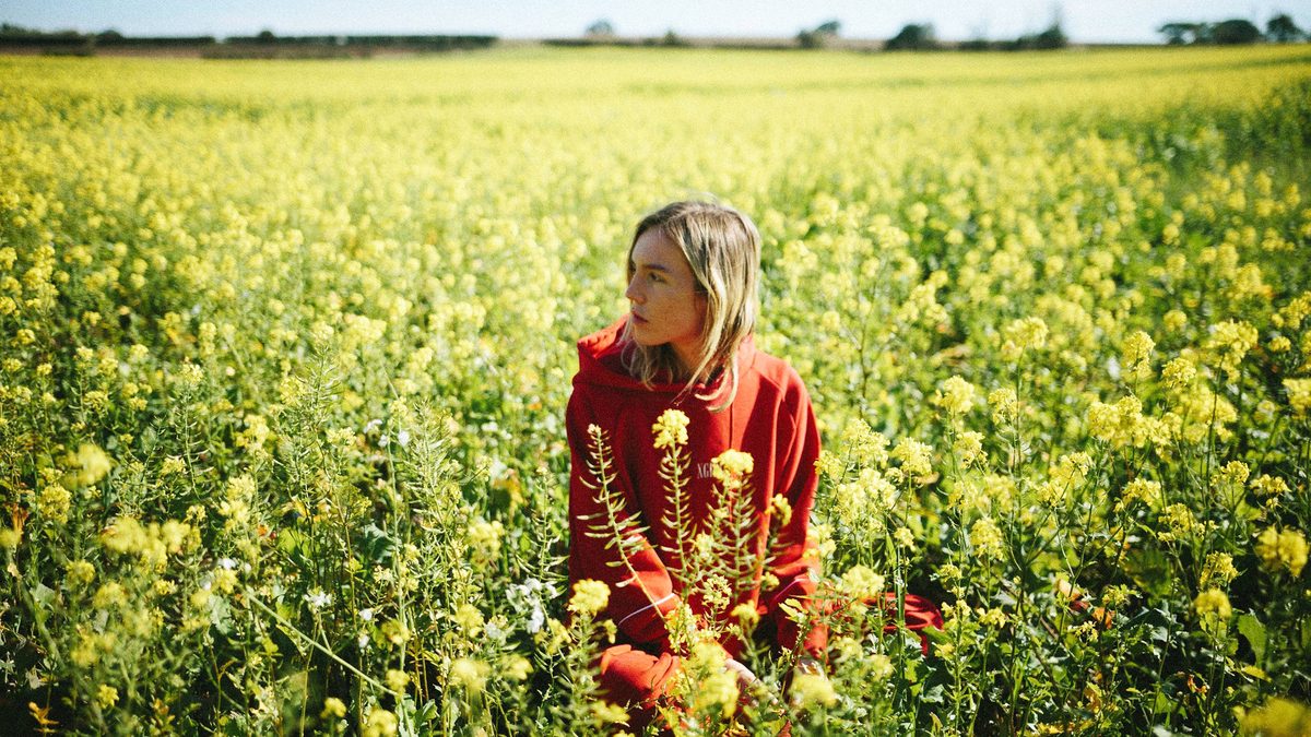 Amber Bain, aka The Japanese House in a field of flowers.