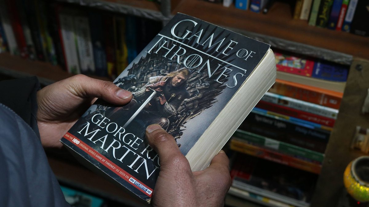 A man holds Game Of Thrones book at the bestseller bookshop in Srinagar.