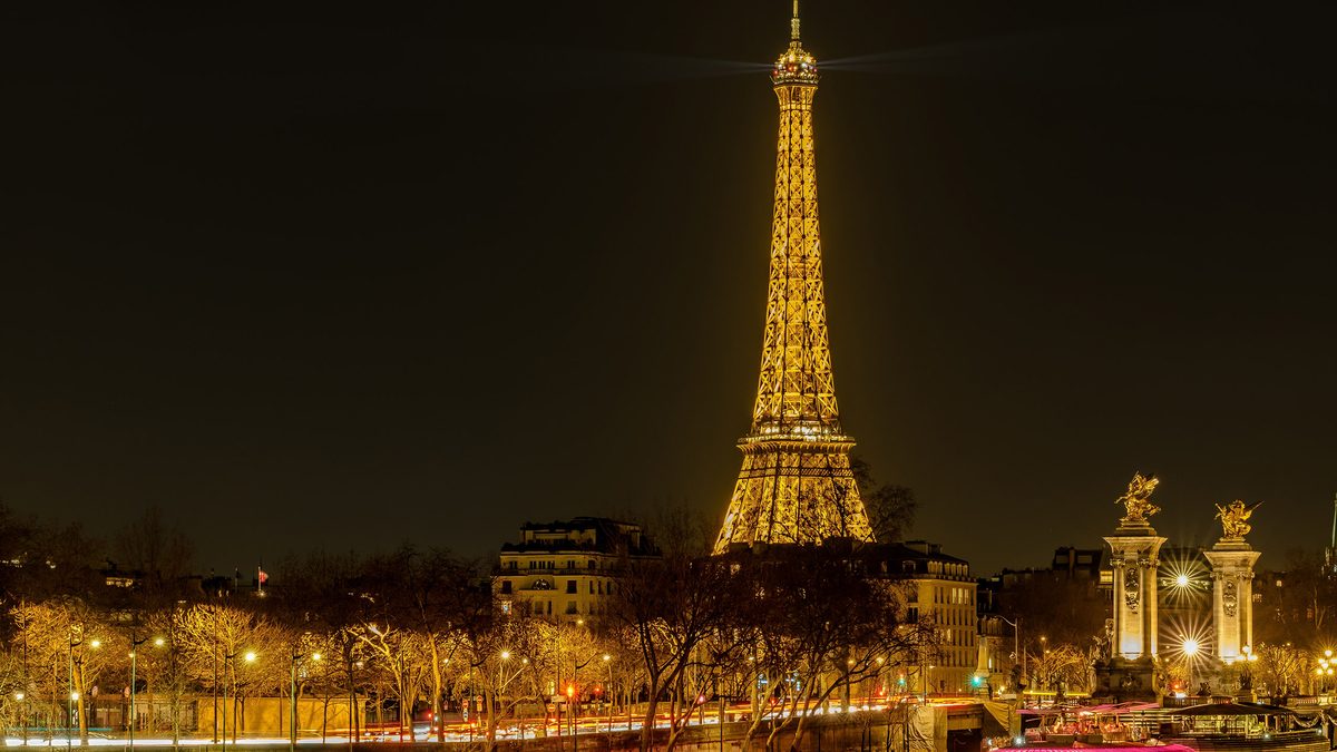 Paris, France - February 17, 2024 : Panoramic view of the illuminated Eiffel Tower and the river Seine in Paris France