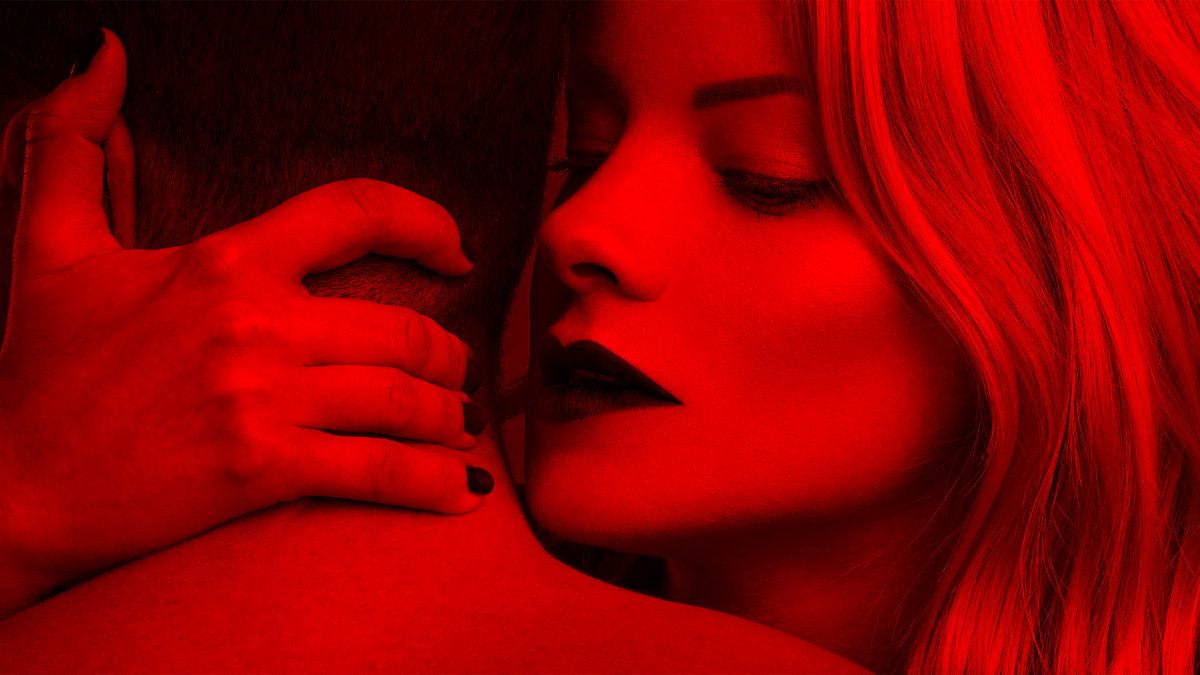 woman whispers in man's ear seductively
