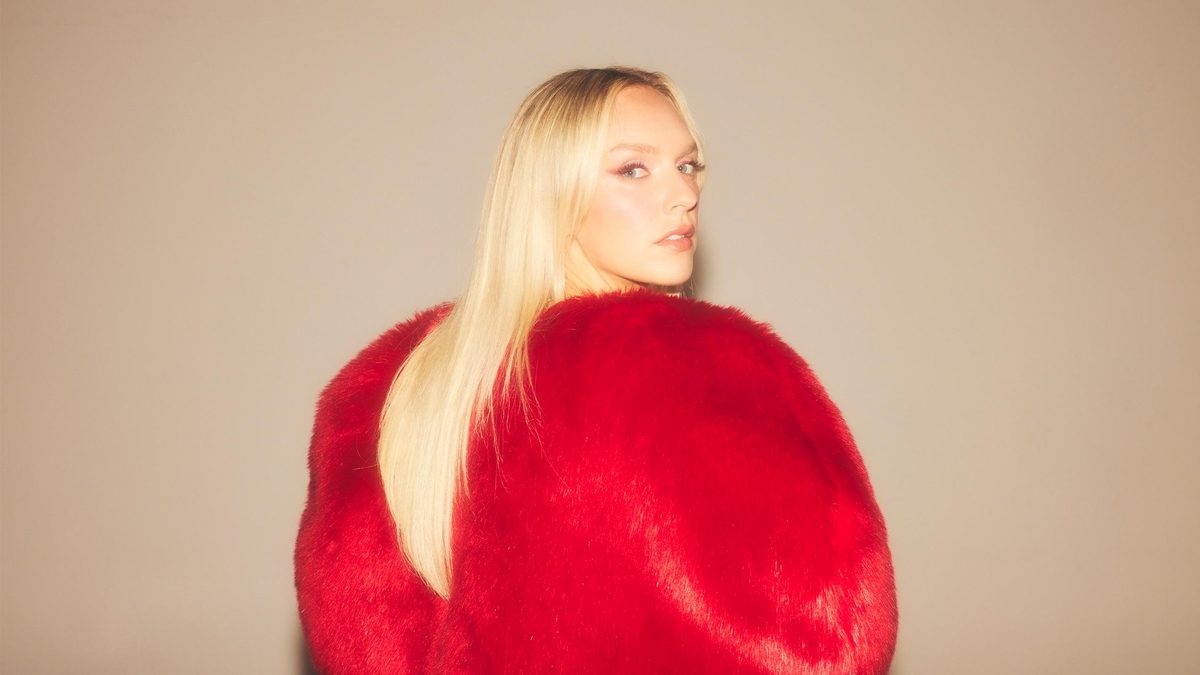 Zolita in red fur against tan background