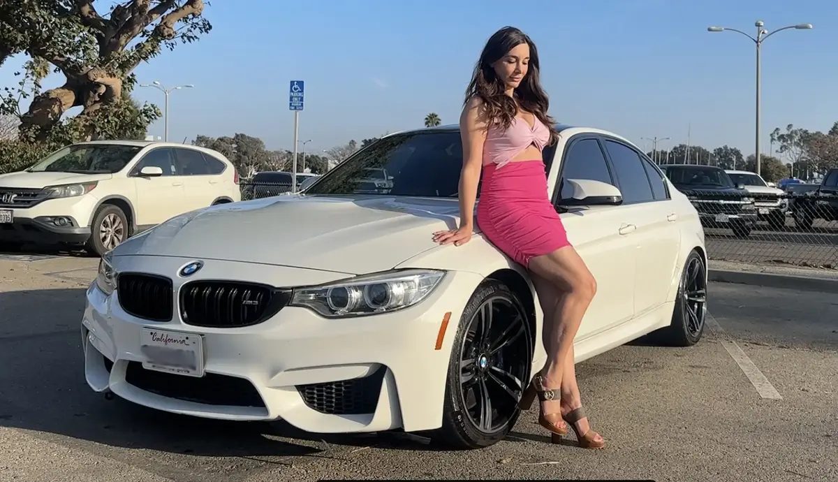 Rebecca Adam standing beside her car.