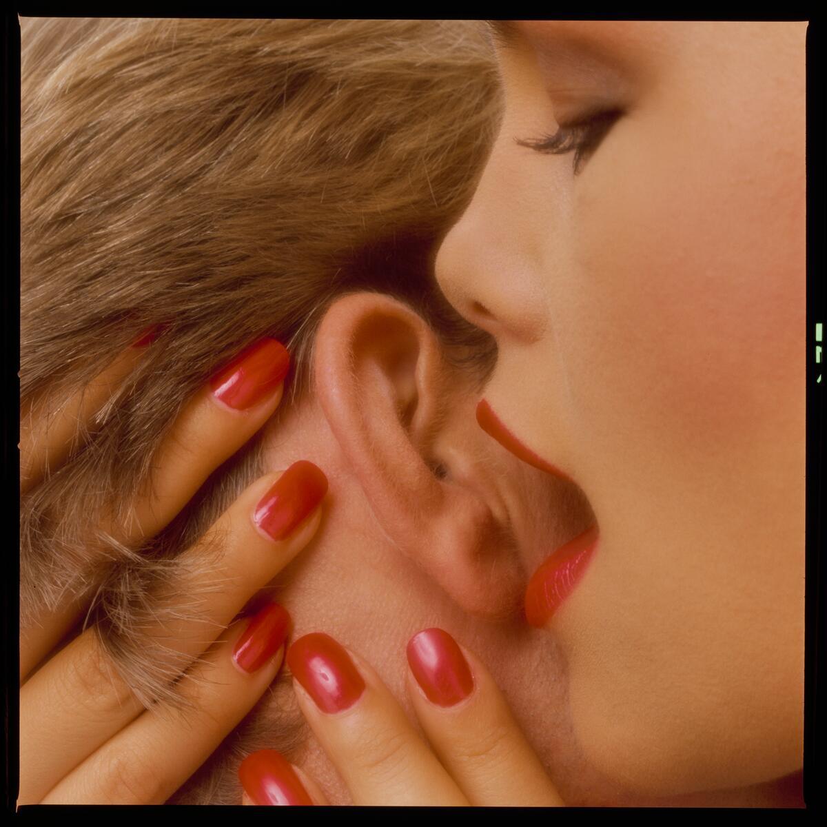 woman whispering in man's ear