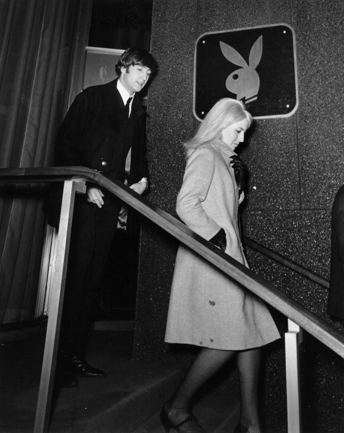 John Lennon and wife Linda walking down the stairs outside a Playboy Club