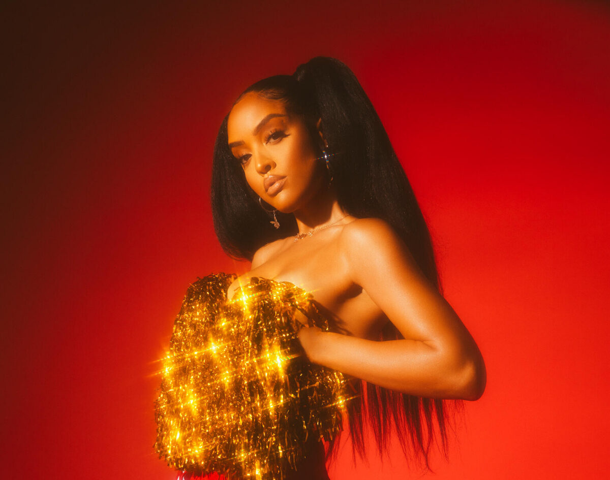 Izabela Guedes golding gold pompoms over her breasts